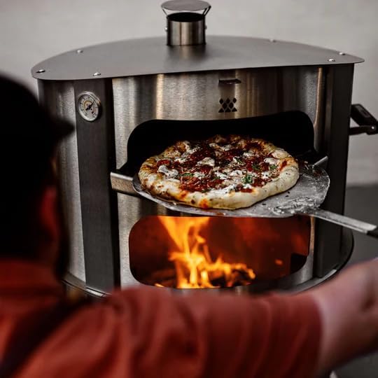 A picture of a pizza cooking with the Breeo Live Fire pizza oven