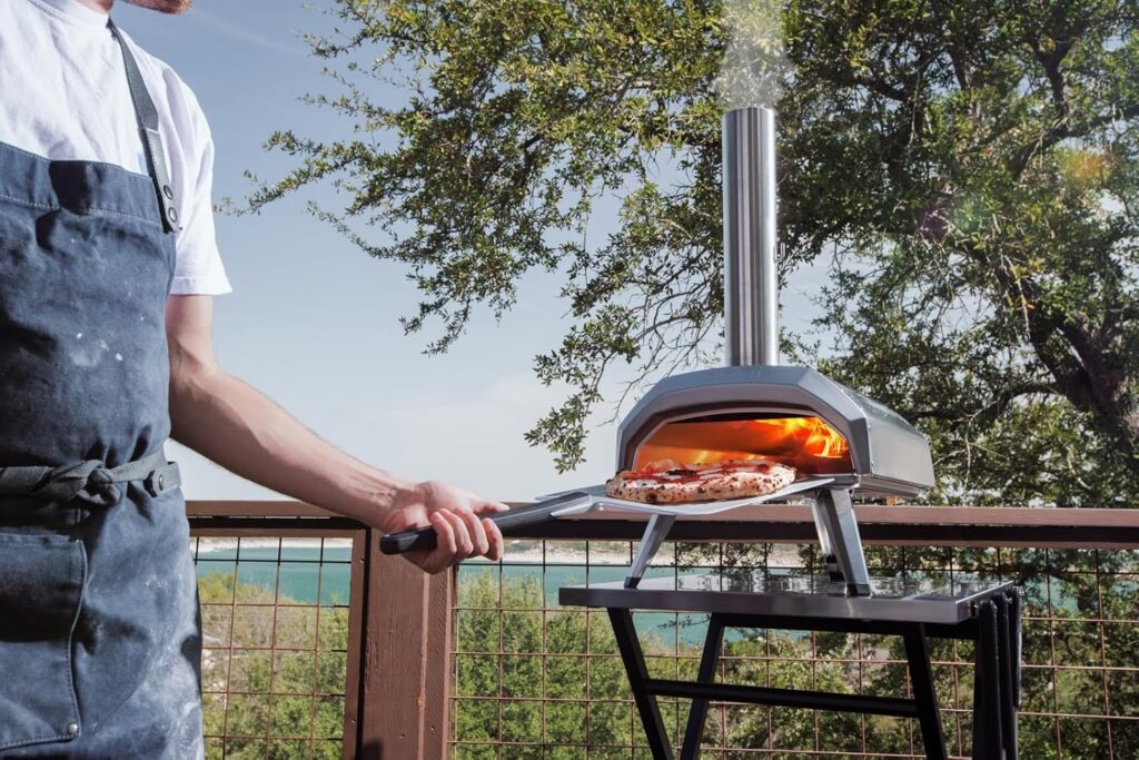 Ooni Karu 12 multi-fuel outdoor pizza oven baking a Neapolitan-style pizza on a patio