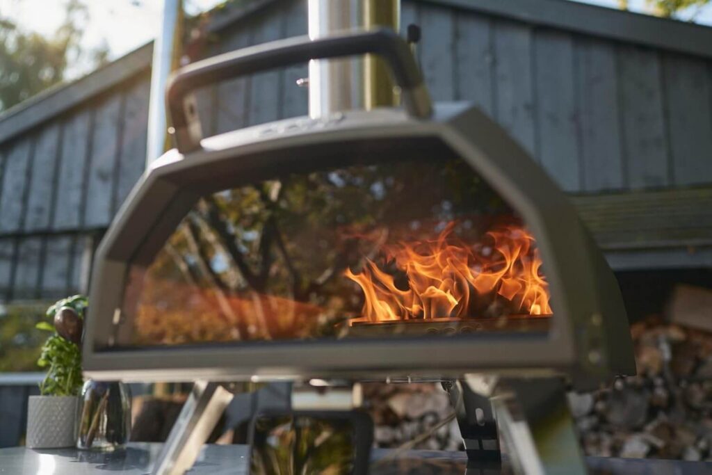 Ooni Karu 2 Pro pizza oven with flames inside.