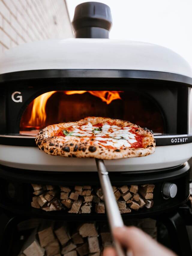 Authentic Neapolitan pizza with mozzarella and basil baking inside a Gozney Dome wood-fired oven