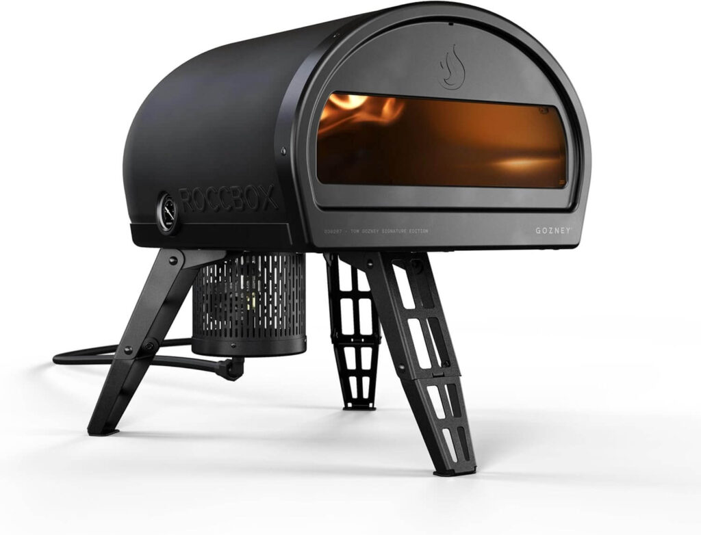 Gozney Roccbox portable pizza oven heating up, showing the flame inside during a real cooking session