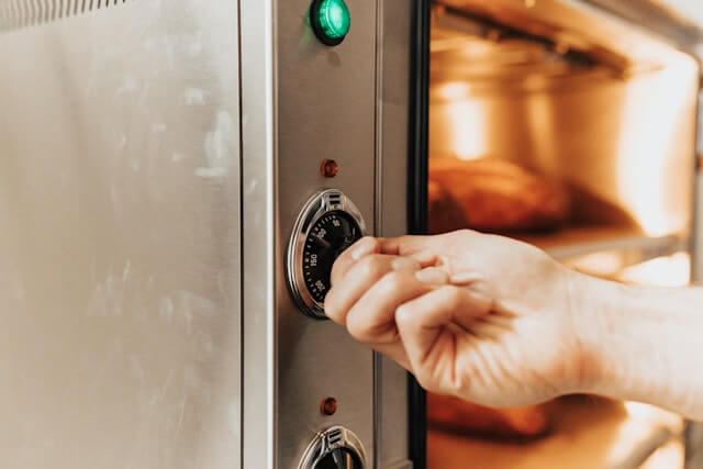 Person opening a home oven and removing food