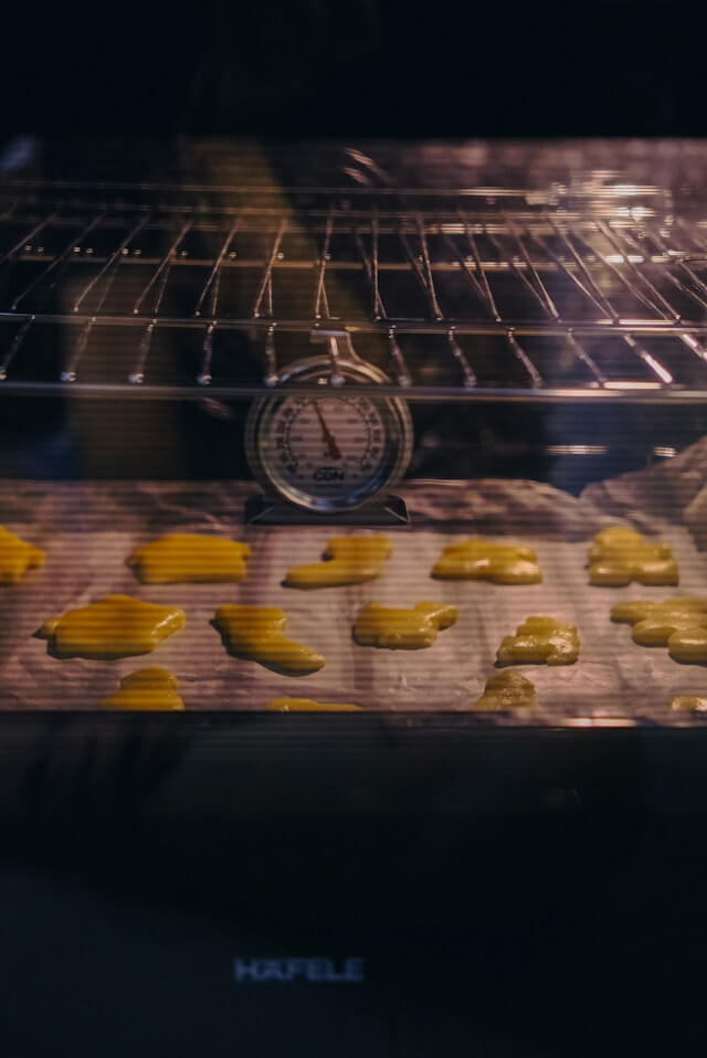 Checking actual oven temperature with thermometer during baking