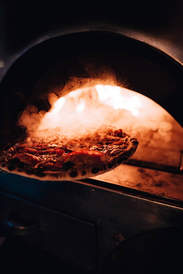 Pizza baking inside a home oven on a tray