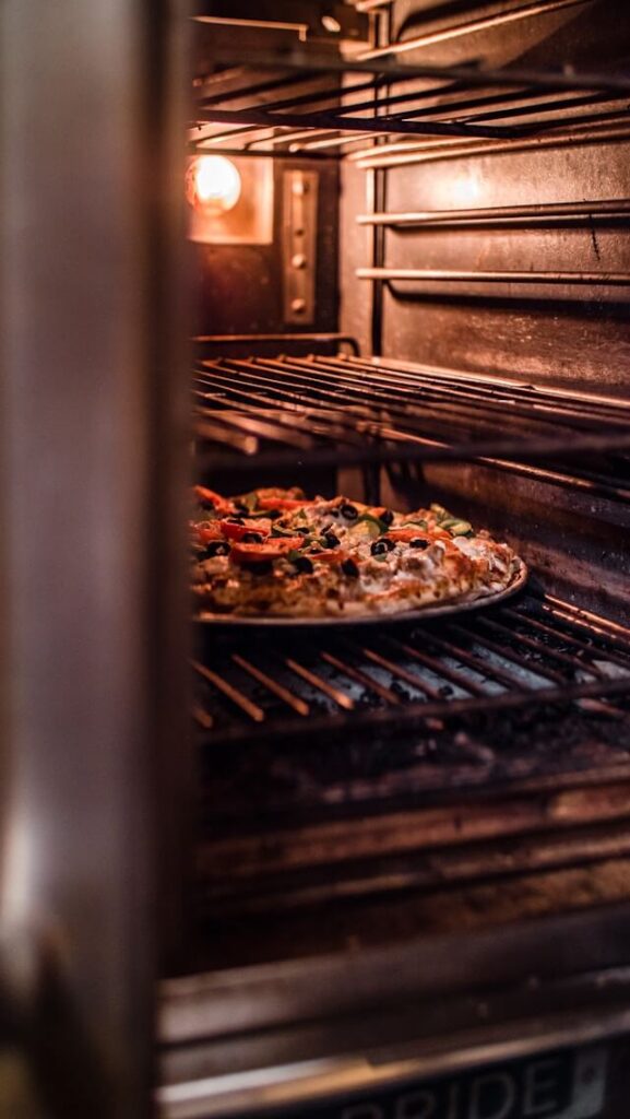 Pizza baking on a pan inside a home oven