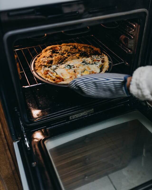 Pizza being removed from a home oven