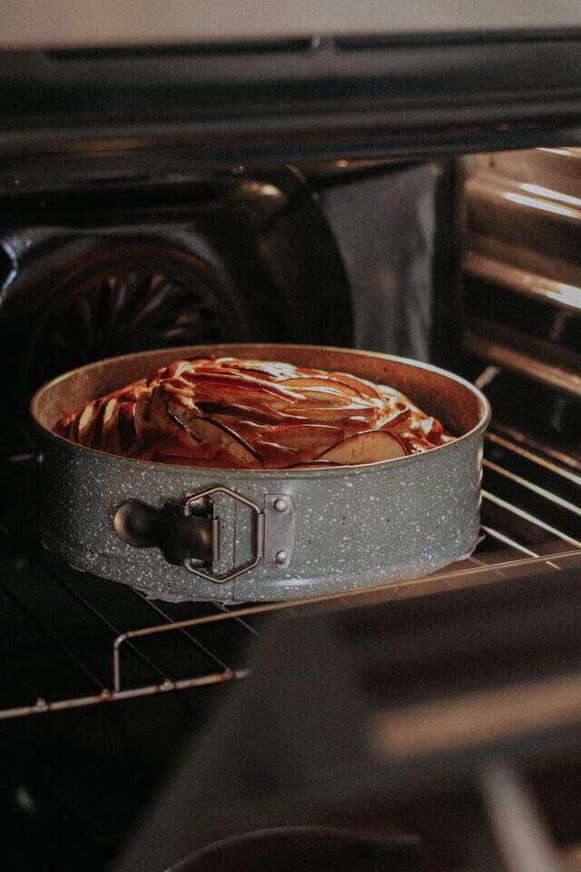 Close-up of a cake baking in a springform pan inside the oven