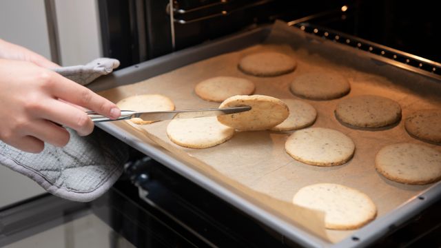 Person lifting a cookie with a spatula to check if it's done baking